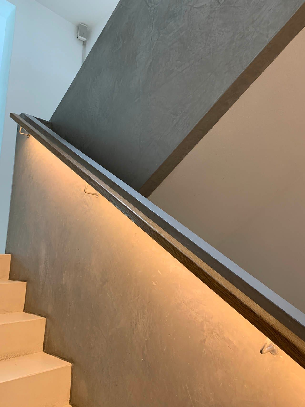 Moderne Treppe mit elegantem Handlauf und Beleuchtung