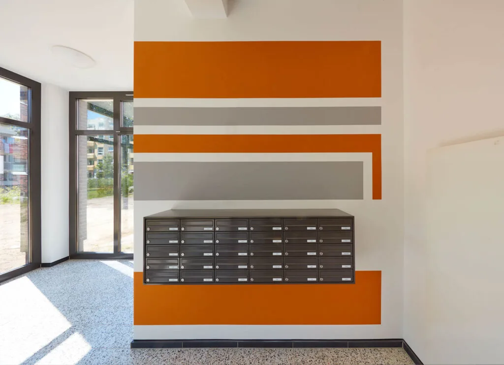 Moderne Briefkästen an einer bunten Wand.
