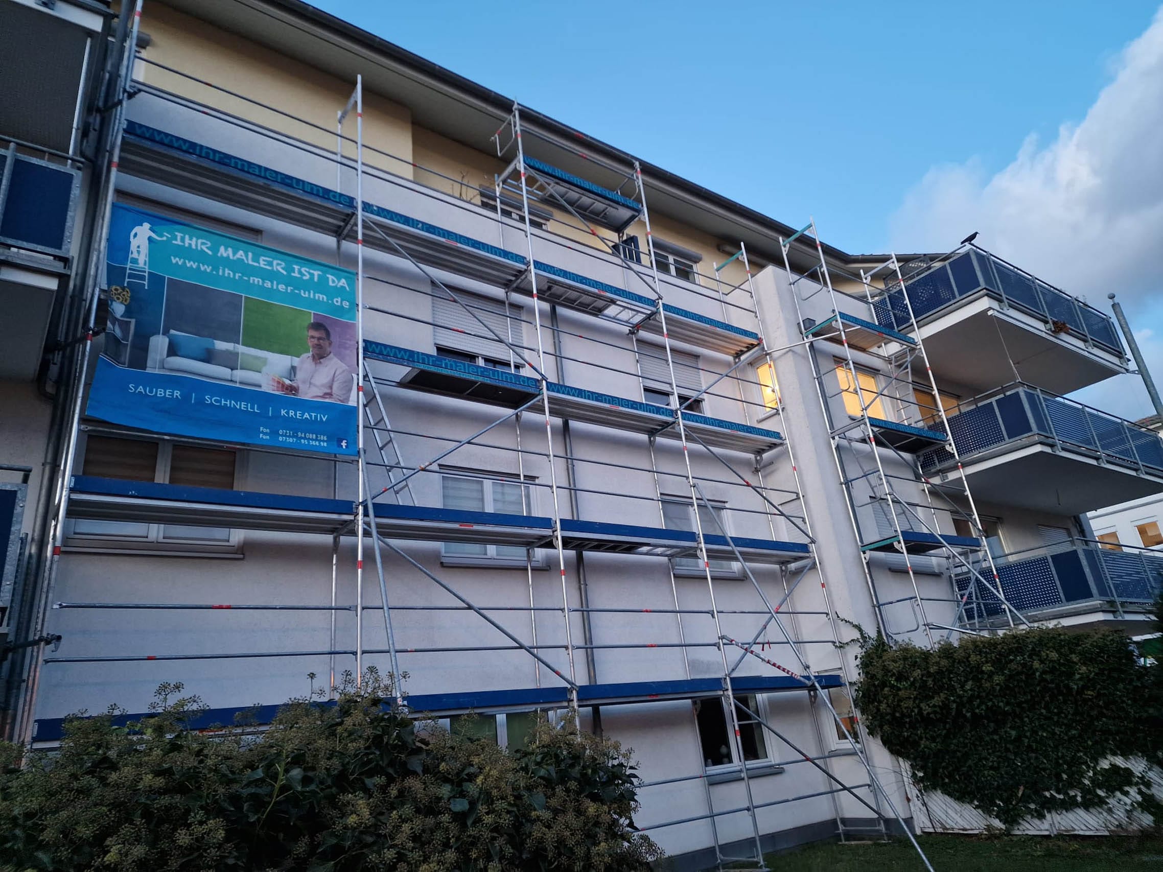 Hausfassade mit Gerüst und Werbebanner