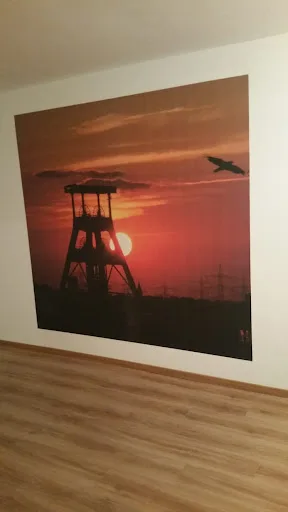 Sonnenuntergang hinter einer Förderturm-Silhouette.