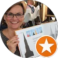 Frau hält ein Buch mit Gebäudeskizzen.